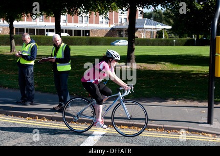 Ciclista in Stratford Triathlon con funzionari registra il suo numero di gara Foto Stock