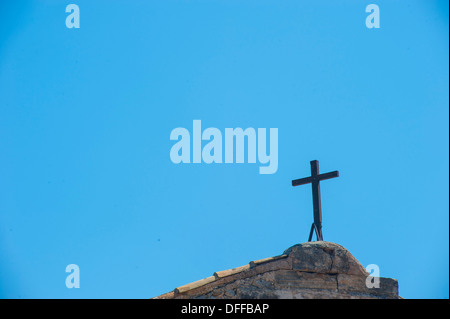 Una semplice chiesa croce contro un luminoso Cielo di estate blu Foto Stock