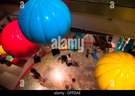 Rosso brillante, blu e giallo modello i palloni ad aria calda sospesi in aria e sul display a Bristol M museo capannone Foto Stock