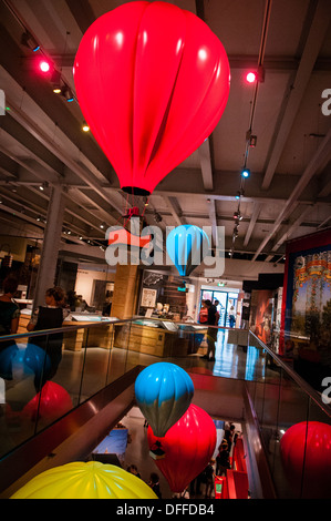 Rosso brillante, blu e giallo modello i palloni ad aria calda sospesi in aria e sul display a Bristol M museo capannone Foto Stock