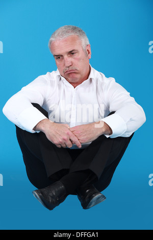 Uomo senior in un vestito cercando triste Foto Stock