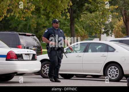 Poliziotto che trasportano un semi-auto fucile in corrispondenza di una scena del crimine - Washington DC, Stati Uniti d'America Foto Stock