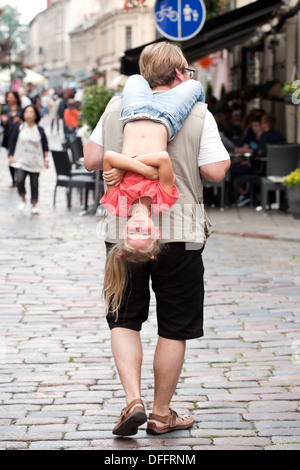 Uomo che porta sulle sue spalle divertente bambina Foto Stock