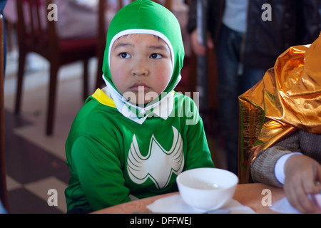 Il ragazzo camuffare se stessi come un batman con vestiti di colore verde Foto Stock