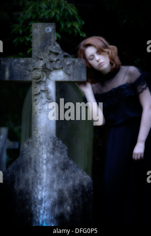 Una ragazza in un abito nero su un cimitero Foto Stock