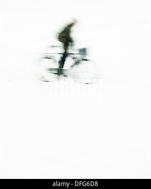 Silhouette con moto sfocata dell uomo in sella a una moto di caduta di neve con camera per copyspace Foto Stock