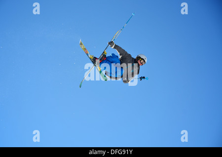 Un sciatore freestyle video se stesso come egli esegue un' antenna trucco lancio da un salto in Les Arcs, Francia. Foto Stock