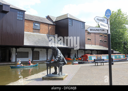 Canoisti canottaggio dalla statua dell'ingegnere, Danielle in Coventry Bacino del canale, Warwickshire, West Midlands, England, Regno Unito Foto Stock