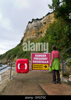 Un viandante si sofferma sulla costa sud ovest percorso per guardare erosione costiera a Seaton, Devon, Inghilterra, Regno Unito Foto Stock