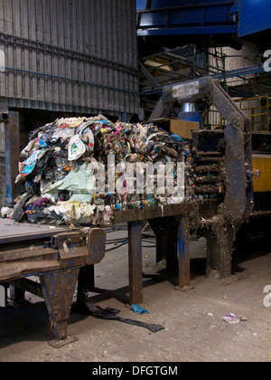 Balla di plastica di scarto sulla pressa idraulica in impianto di riciclaggio. La plastica è separato dai rifiuti domestici Foto Stock