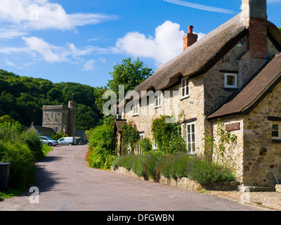 Cottage con tetto in paglia e St Winifred's church, Branscombe Devon England Foto Stock