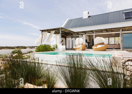 Piscina, sedie e di un patio di casa moderna Foto Stock