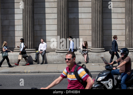 Un uomo dorme sotto il sole durante il tempo caldo appoggiata contro la Banca di Inghilterra a Londra il 9 luglio 2013. Foto Stock