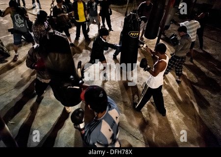 Giovani peruviani pratica con sacchetti di punzonatura durante la serata al boxeo vmt boxing club in una palestra a cielo aperto in Lima, Perù. Foto Stock