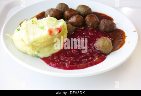 Cibo che viene mangiato. Polpette svedese di mirtillo palustre di patate sul piatto. Un tradizionale scandinavo culinario. Foto Stock