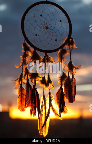 Un dream catcher sulla finestra con il tramonto sullo sfondo Foto Stock