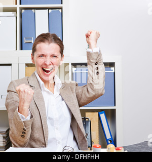 Gli anziani di successo business donna tifo nel suo ufficio Foto Stock