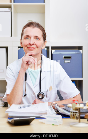 Ritratto di felice senior medico donna nel suo ufficio Foto Stock