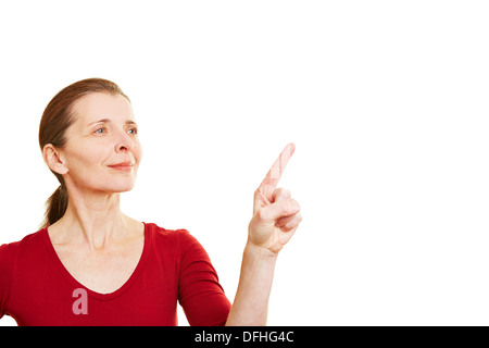 Senior di puntamento della donna con il suo dito indice per touchscreen invisibile Foto Stock
