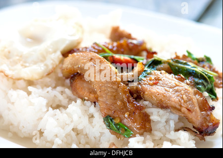 Riso con stir fritti caldi e carne di maiale piccante con basilico Foto Stock
