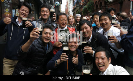 I turisti a Dublino Guinness bevanda su una strada durante l'Arthur's celebrazioni del Giorno Dubln nel centro citta'. Foto Stock