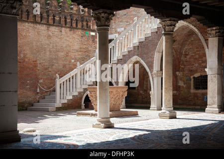 Nel sestiere di Cannaregio a Venezia, il cortile interno di palazzo Ca' d'Oro con scale e ben (Italia). Foto Stock