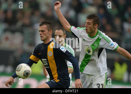 Wolfsburg, Germania. 05 ott 2013. Wolfsburg Robin Knoche (R) e di Braunschweig Orhan Ademi si contendono la palla durante la Bundesliga partita di calcio VfL Wolfsburg vs Eintracht Braunschweig a Volkswagen-Arena a Wolfsburg, in Germania, 05 ottobre 2013. Foto: PETER STEFFEN (ATTENZIONE: grazie alle linee guida di accreditamento, il DFL consente solo la pubblicazione e utilizzazione di fino a 15 immagini per corrispondenza su internet e nei contenuti multimediali in linea durante la partita.)/dpa/Alamy Live News Foto Stock