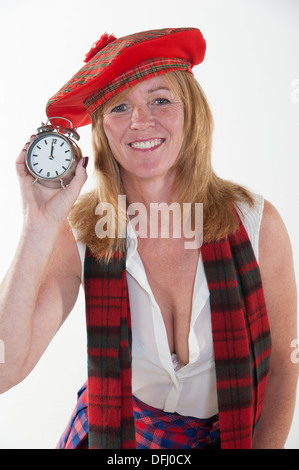 La donna per celebrare il nuovo anno come mezzanotte colpisce per il suo orologio Foto Stock
