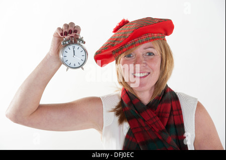 La donna per celebrare il nuovo anno come mezzanotte colpisce per il suo orologio Foto Stock