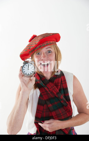 La donna per celebrare il nuovo anno come mezzanotte colpisce per il suo orologio Foto Stock