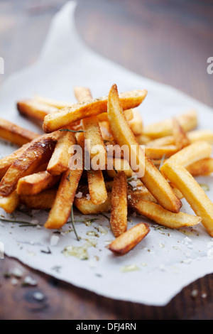 Dorate e croccanti patatine fritte con sale ed erbe Foto Stock