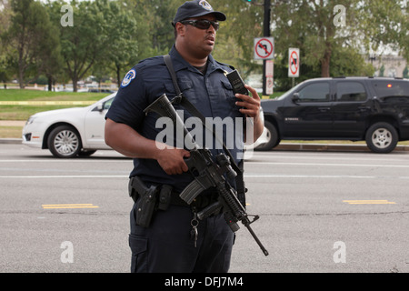 Poliziotto che trasportano un semi-auto fucile in corrispondenza di una scena del crimine - Washington DC, Stati Uniti d'America Foto Stock