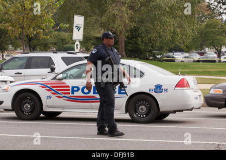 Poliziotto che trasportano un semi-auto fucile in corrispondenza di una scena del crimine - Washington DC, Stati Uniti d'America Foto Stock