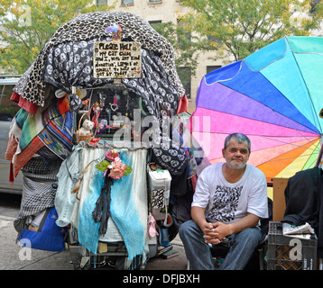 Un panhandler con un display innovativo nell'East Village di New York City per chiedere i soldi che aiuta ad alimentare il suo gatto Chloe. Foto Stock