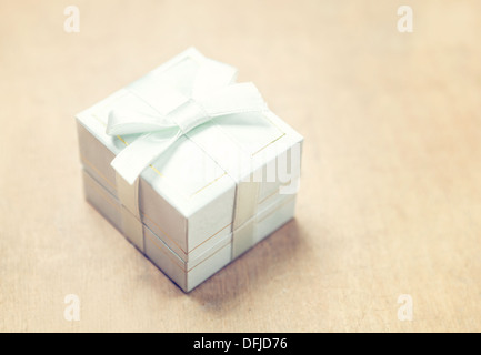 Confezione regalo con nastro bianco su sfondo beige Foto Stock