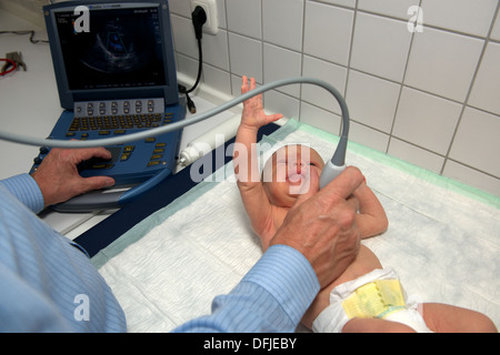 Medico usando un Fujifilm SonoSite MicroMaxx portable macchina ad ultrasuoni per esaminare un battito del cuore del bambino Foto Stock