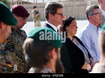 Kunduz , Afghanistan. 06 ott 2013. Il Ministro degli esteri tedesco Guido Westerwelle (C) e il Ministro della difesa Thomas de Maiziere (R) pagare i loro versi in un memoriale per i soldati uccisi insieme con Tanja Menz, il cui figlio Konstantin è stato ucciso durante il suo dovere in Afghanistan, dopo la cerimonia di passaggio di una base di tedesco a favore delle forze armate in Kunduz , Afghanistan, 06 ottobre 2013. Soldati della contingenza tedesco della Forza internazionale di assistenza alla sicurezza (ISAF) ha ritirato dalla loro base a Kunduz e il campo sarà utilizzato dall'Esercito nazionale afgano e la Nazionale Afghano o civile... Foto Stock