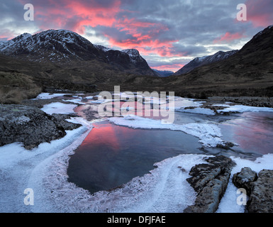 Tramonto in inverno oltre il Pass di Glencoe nelle Highlands della Scozia Foto Stock