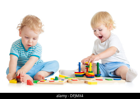 Concentrato di bambino che gioca l'istruzione logica giocattoli con grande interesse su sfondo bianco Foto Stock