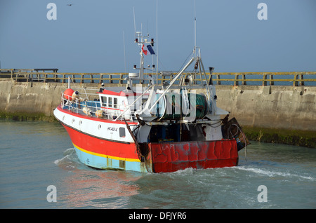 Una barca da pesca lasciando Grandcamp del porto al tramonto. Foto Stock