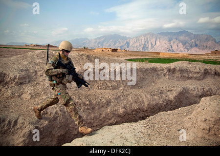 Un marine statunitense salta attraversare un canale di irrigazione durante una pattuglia attraverso villaggi contadini Dicembre 15, 2012 nella provincia di Farah, Afghanistan. Foto Stock