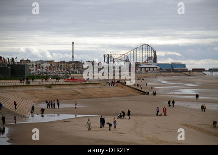 Guardando verso il basso Blackpool frontale verso South Pier famiglie giocando sulla spiaggia e il Big One roller coaster a distanza Foto Stock