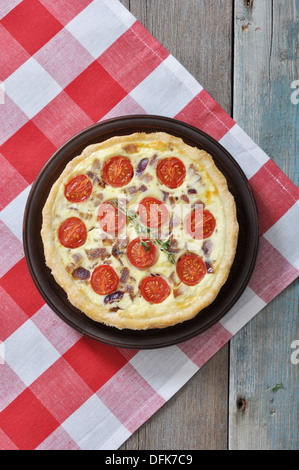 Francese tradizionale torta quiche con pollo e pomodoro ciliegino su una piastra Foto Stock