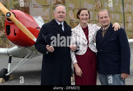 Finsterwalde, Germania. 07 ott 2013. Attori Harald Krassnitzer (L-R) come Elly il padre, Vicky Krieps come Elly Beinhorn e Christian Berkel come Ernst Udet pongono durante le riprese del ZDF film della televisione 'Solo volo - Elly Beinhorn' (titolo di lavoro) al campo di aviazione di Finsterwalde Finsterwalde, Germania, 07 ottobre 2013. Foto: BRITTA PEDERSEN/dpa/Alamy Live News Foto Stock