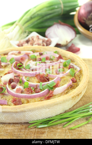 Onion tart con porri e pancetta affumicata su uno sfondo luminoso Foto Stock