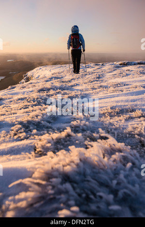 Escursionista femmina all'alba sul vertice di inverno di Pen Y ventola, Parco Nazionale di Brecon Beacons, Galles Foto Stock