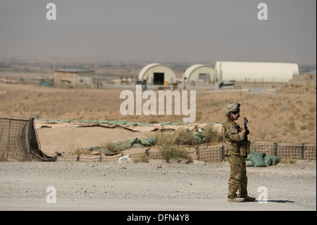 Il personale Sgt. Juan Pareja, 455th Expeditionary forze di sicurezza Squadron Fly-Away Security Team Airman, fornisce la sicurezza come 774th Airlift Expeditionary Squadron C-130 Hercules loadmasters spostare l'ultima porzione di carico da inoltrare una base operativa Sharana, Pa Foto Stock