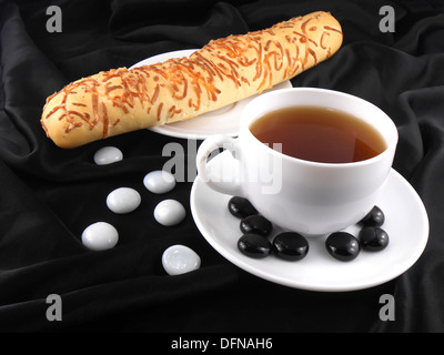 Caffè caldo con pane e pietre su sfondo nero Foto Stock