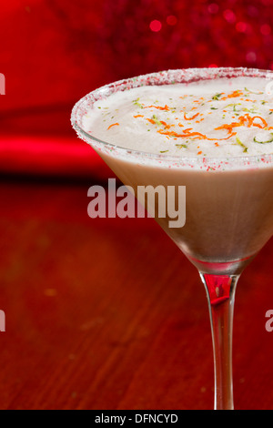 Holiday martini con un cerchio di zucchero e la calce e la scorza di arancia e servite su un tavolo con decorazioni Foto Stock