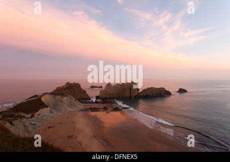 Le formazioni rocciose e spiaggia lungo la costa di Arnia al crepuscolo, Los Pielagos, Camino de la Costa, il Camino del Norte, percorso costiero, W Foto Stock